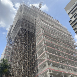 Andaime modular e fachadeiro ao redor de um prédio fazendo a proteção e o escoramento.