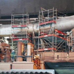 Andaimes montados embaixo e ao redor de dutos em planta industrial, feito para manutenção